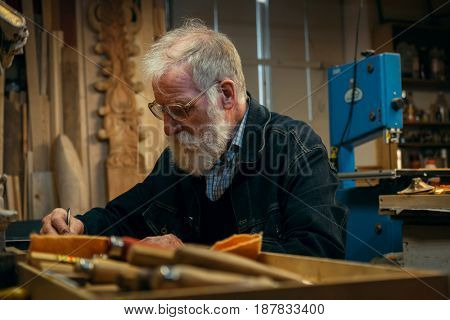 Senior wood carving professional during work