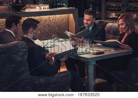 Friends rading menu in a restaurant.