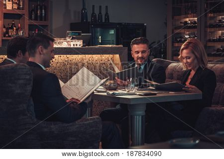 Friends rading menu in a restaurant.