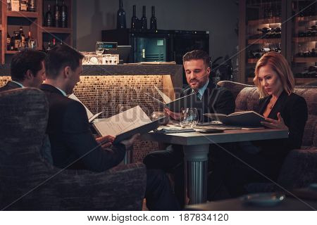 Friends rading menu in a restaurant.