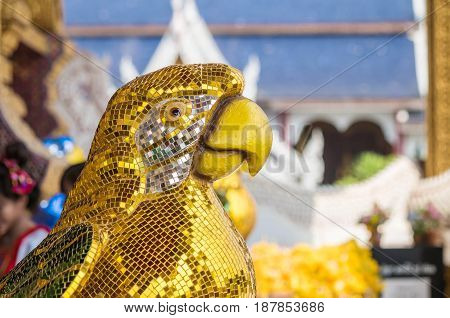 Closeup beautiful parrot bird statue by yellow tiles for decorate in temple of thailand background