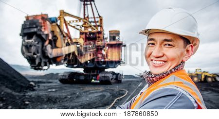coal mining worker with rotary excavator on the background