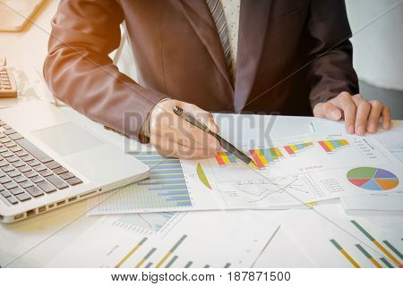 Close up of hand of business man working document and laptop in office morning light. business concept.