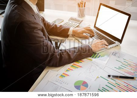 Close up of hand of business man working document and laptop in office morning light. business concept.