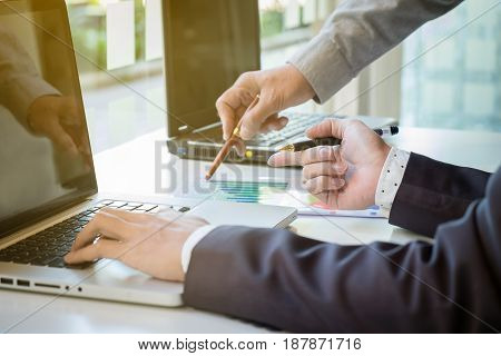 Two businessmen looking at report and having a discussion in office. business concept.