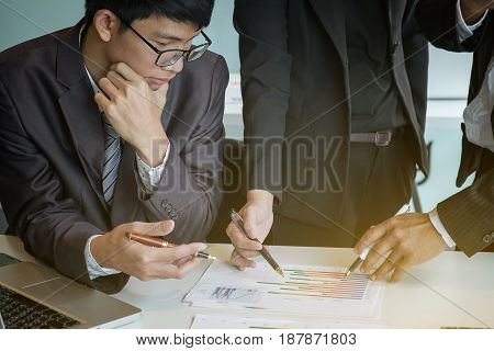 business Teamwork looking at report and having a discussion in office.