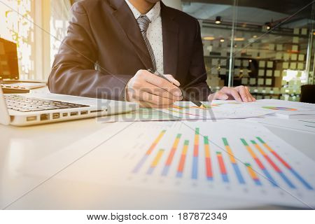 Close up of hand of business man working document and laptop in office morning light. business concept.
