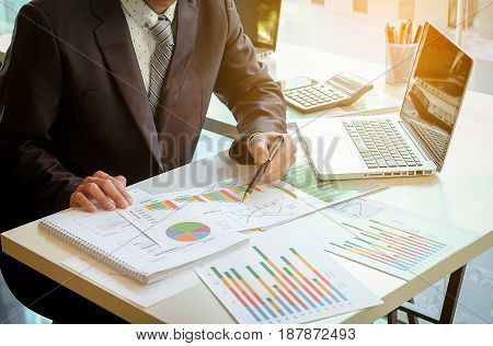Close up of hand of business man working document and laptop in office morning light. business concept.