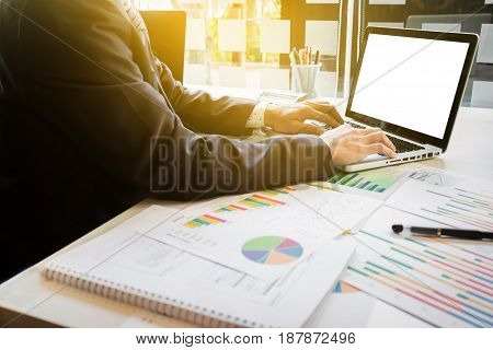 Close up of hand of business man working document and laptop in office morning light. business concept.