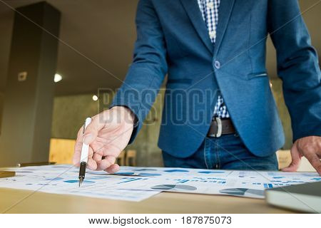 Close up of hand of business man working document and laptop in office morning light. business concept.