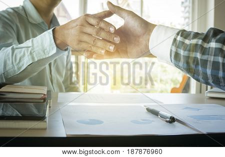 Two businessmen shaking hands during a meeting in the office success dealing greeting & business partner.