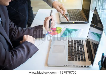 Two businessmen looking at report and having a discussion in office. business concept.