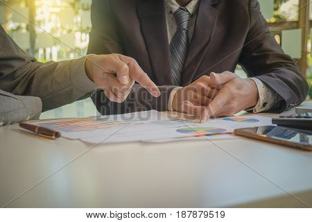 Two businessmen looking at report and having a discussion in office. business concept.