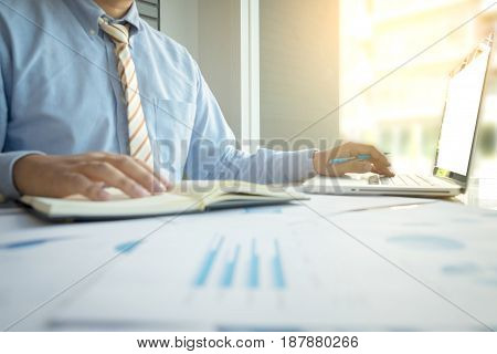 business man working document and laptop in office desk morning light. business concept.