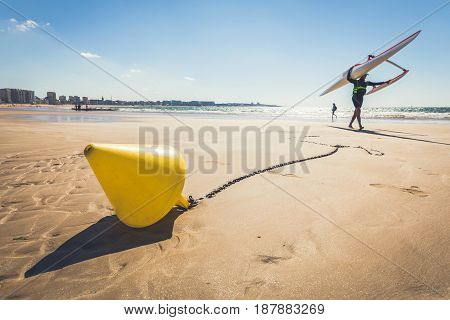 Yellow conical buoy on the beach of Les Sables d'Olonne at low tide