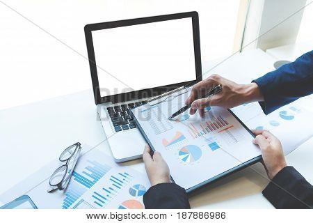 Business people discussing the charts and graphs showing the results of their successful teamwork business concept.