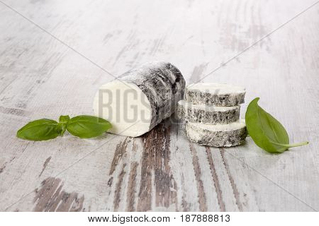 Goat cheese with basil on wooden table. Rustic vintage goat cheese background.