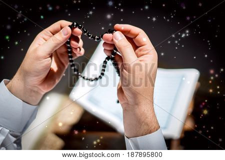 Muslim man hands holding rosary with quraan