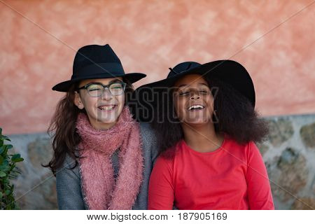 Two happy girls friends with stylish hats lauging 