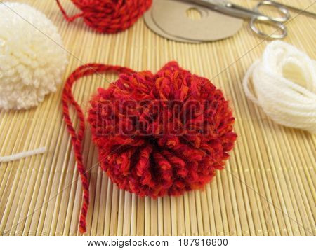 Making of small pompons in red and white