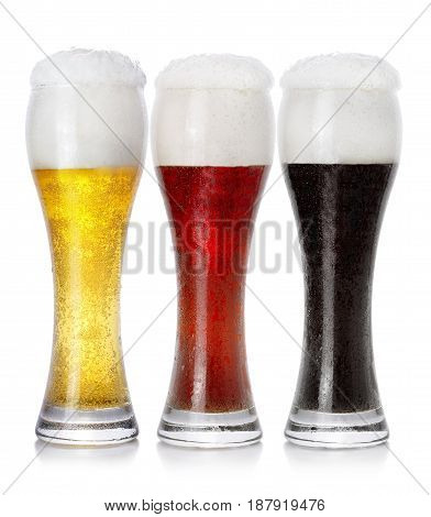 Three glasses of different fresh foamy beer on white background