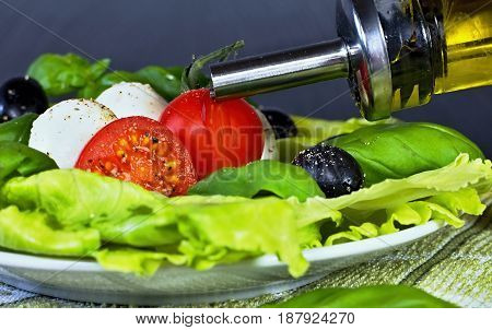 Caprese salad. Classic caprese salad. Italian traditional caprese salad ingredients. Mediterranean food. Caprese salad Tomato and mozzarella with basil leaves on wooden background.