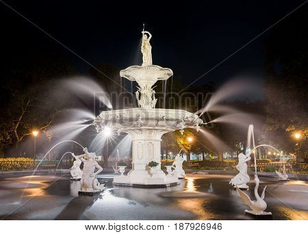 Water fountain at night Forsyth fountain in historic Savannah Georgia. Dramatic view with statues and water spray.