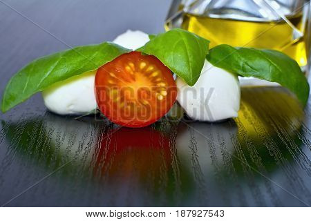 Caprese salad. Classic caprese salad. Italian traditional caprese salad ingredients. Mediterranean food. Caprese salad Tomato and mozzarella with basil leaves on wooden background.