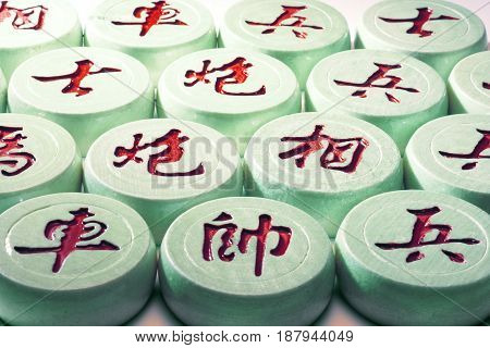 Close Up of Chinese Chess Pieces in Green Cast