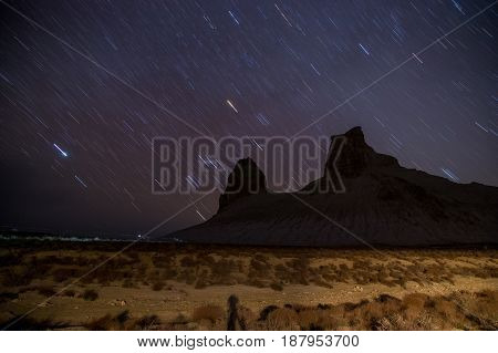 Star trails at night over Boszhira mountain canyon, Mangistau, Mangishlak, Kazakhstan desert in the spring