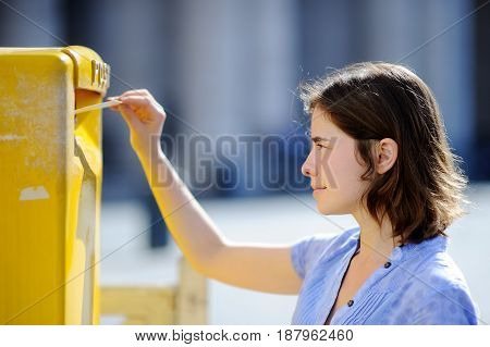 Girl Drops A Postcard In A Mailbox In The Vatican