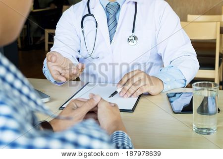 Patient Listening Intently To A Male Doctor Explaining Patient Symptoms Or Asking A Question As They