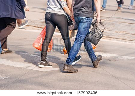 people crossing the pedestrian crossing on sunny spring day