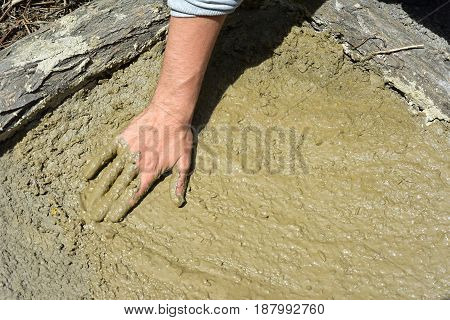 Dirty muddy hands prepare the soil of a vegetable garden