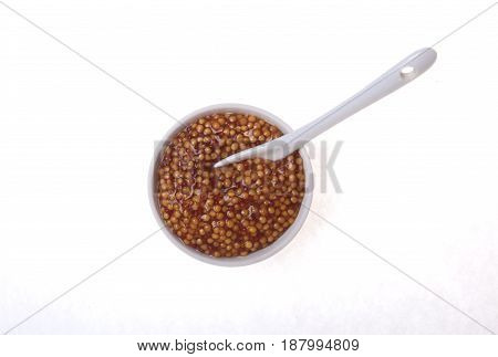 Typical french dijon rough mustard in bowl from isolated on white background.