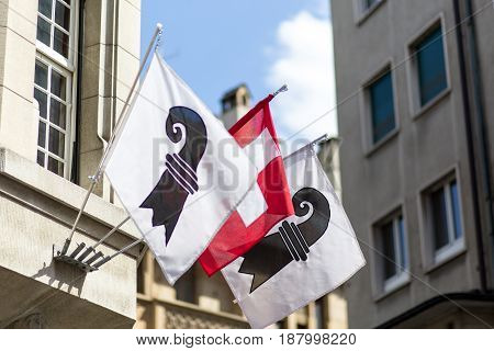 One Swiss flag in between two flags of the swiss canton of Basel
