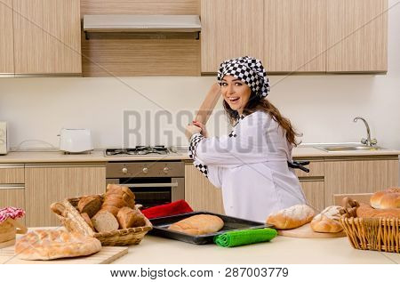 Young female baker working in kitchen 