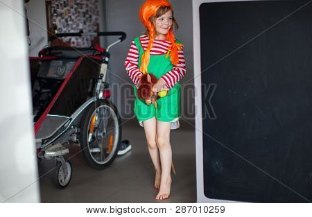 Little girl dressed up as Pippi Longstocking at home