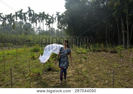 A Beautiful Girl Wearing Blue Color Salwar Kameez Flying Her Dupatta In Air In The Field On A Sunny 