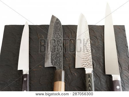 Set of new and used knives on black wooden board