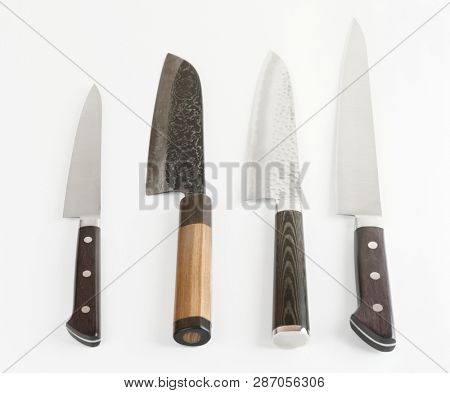 Four different knives shot on light gray surface with smooth shadows