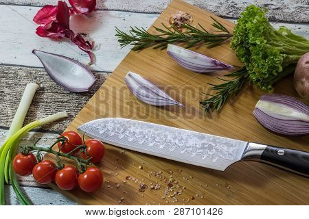 Knife With Healthy Food - Vegetables, Onion, Salad, Tomatoes, Potato Placed On A Cutting Board With 