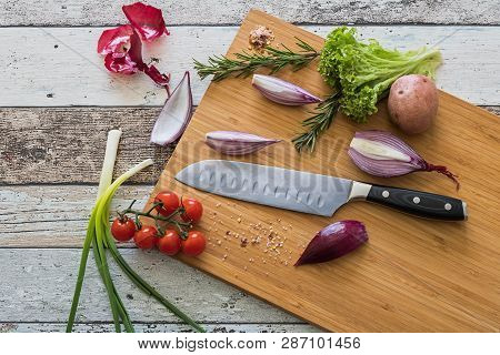 Knife With Healthy Food - Vegetables, Onion, Salad, Tomatoes, Potato Placed On A Cutting Board With 