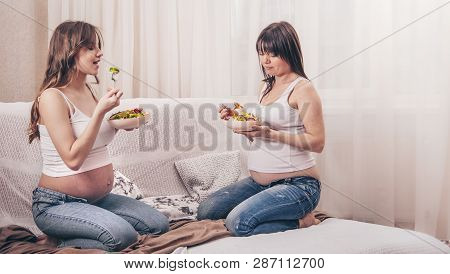 Maternity Concept, Two Pregnant Women Eating Fresh Salad At Home