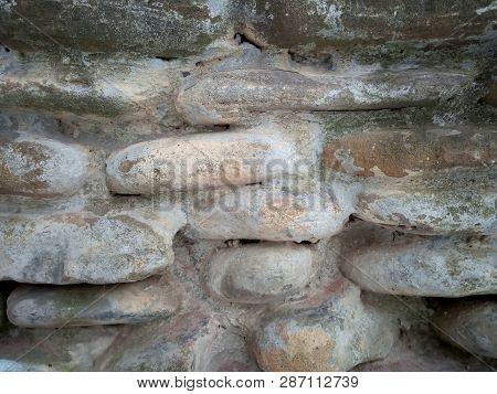 Bulging Stoned Wall Background. Oblong Stone Texture. Fragment Of Stoned Wall. Close-up