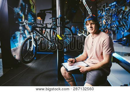Young Handsome Stylish Man In A Cap Snapback And With A Tattoo Small Business Owner Selling A Bicycl