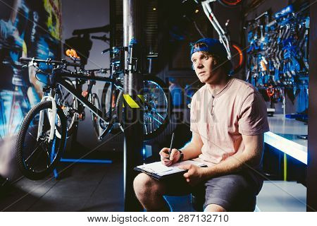 Young Handsome Stylish Man In A Cap Snapback And With A Tattoo Small Business Owner Selling A Bicycl