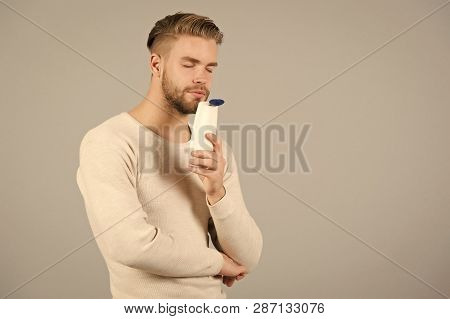 My Favorite Aroma. Man Stylish Hairstyle Holds Bottle Conditioner Grey Background. Limit Washing And
