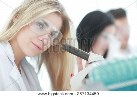 Close Up.a Modern Female Scientist Looks Into A Microscope In A Laboratory