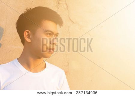 Photo Of A Young Thai Boy Is Standing Front Of The Dirty Wall In The White Shirt With Smilingly Happ